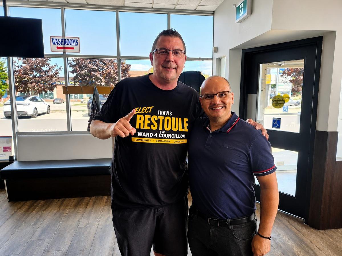 Travis Restoule, wearing his campaign t-shirt, visiting a local Ward 4 business owner